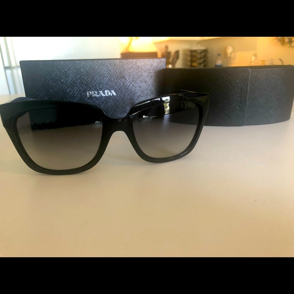 Classic and sheek, black Prada sunglasses with gradient lense.